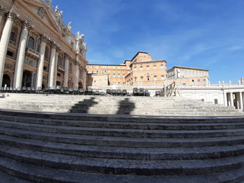 Fountain in front of historic building against sky