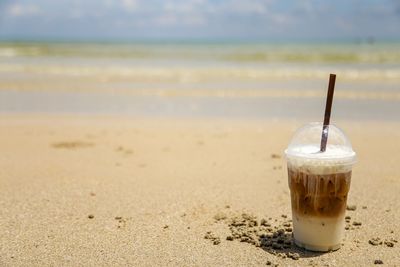 Close-up of coffee on table at beach