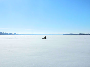 Person sitting on snow covered field