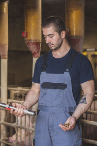 Pig farm worker holding a gun for the humane killing of animals