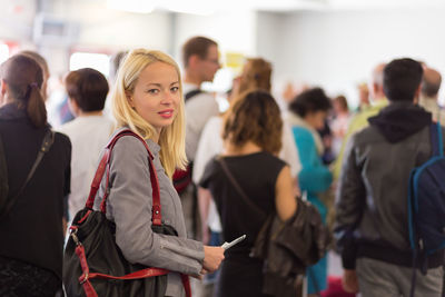 Portrait of mid adult woman standing at airport