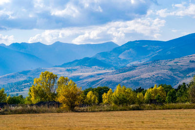 Scenic view of field and mountains against sky