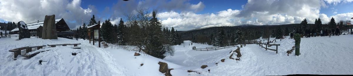 Panoramic view of snow covered field against sky