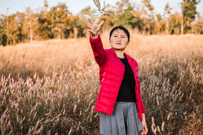 Portrait of smiling young woman standing on field