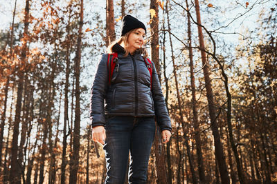Woman enjoying hike on sunny vacation day. female with backpack walking through forest path
