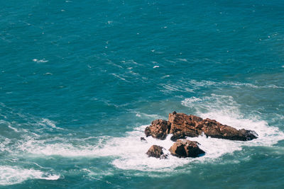 High angle view of people on rocks by sea