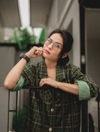 Portrait of woman with head cocked standing at home