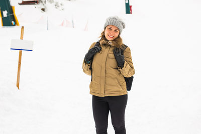 Portrait of smiling woman standing in snow