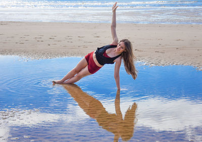 Woman with arms raised on beach