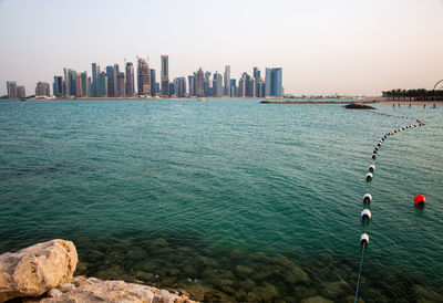 View of sea and buildings against sky