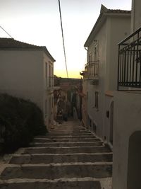 Steps amidst houses against sky