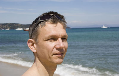 Close-up of mature man looking away while standing on shore