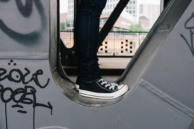 Low section of person standing on metal structure