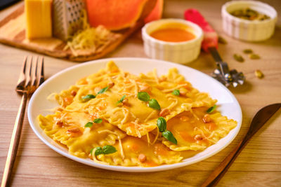 Homemade pumpkin ravioli with ricotta cheese served basil