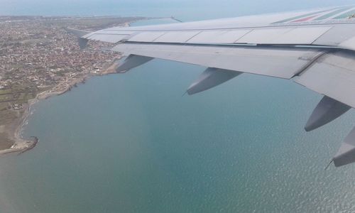 Cropped image of airplane flying over cityscape