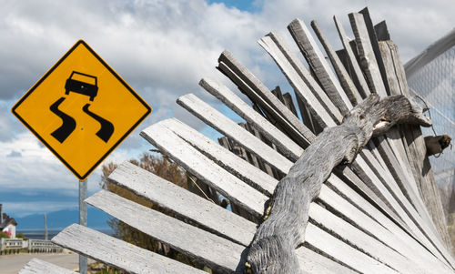 Close-up of road sign against fence