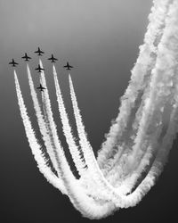Low angle view of airshow against sky