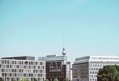 Buildings in city against clear sky