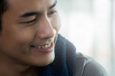 Close-up portrait of smiling young woman looking away