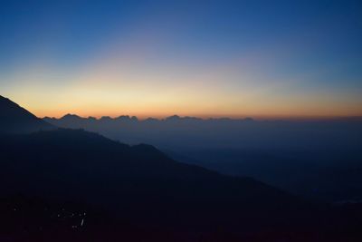 Scenic view of silhouette mountains against sky at sunset