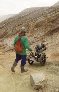 Sulphur miners activity at the top of mount ijen in banyuwangi, indonesia.