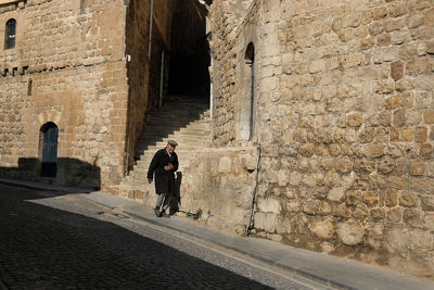 Man standing by old wall