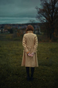 Rear view of woman walking on field