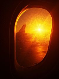 Close-up of illuminated lamp against orange sky