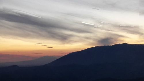 Scenic view of silhouette mountains against sky at sunset