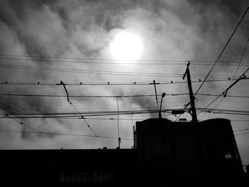 Low angle view of silhouette electricity pylon against sky