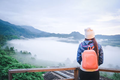 Rear view of woman at observation point against mountains