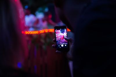 People photographing illuminated smart phone at night