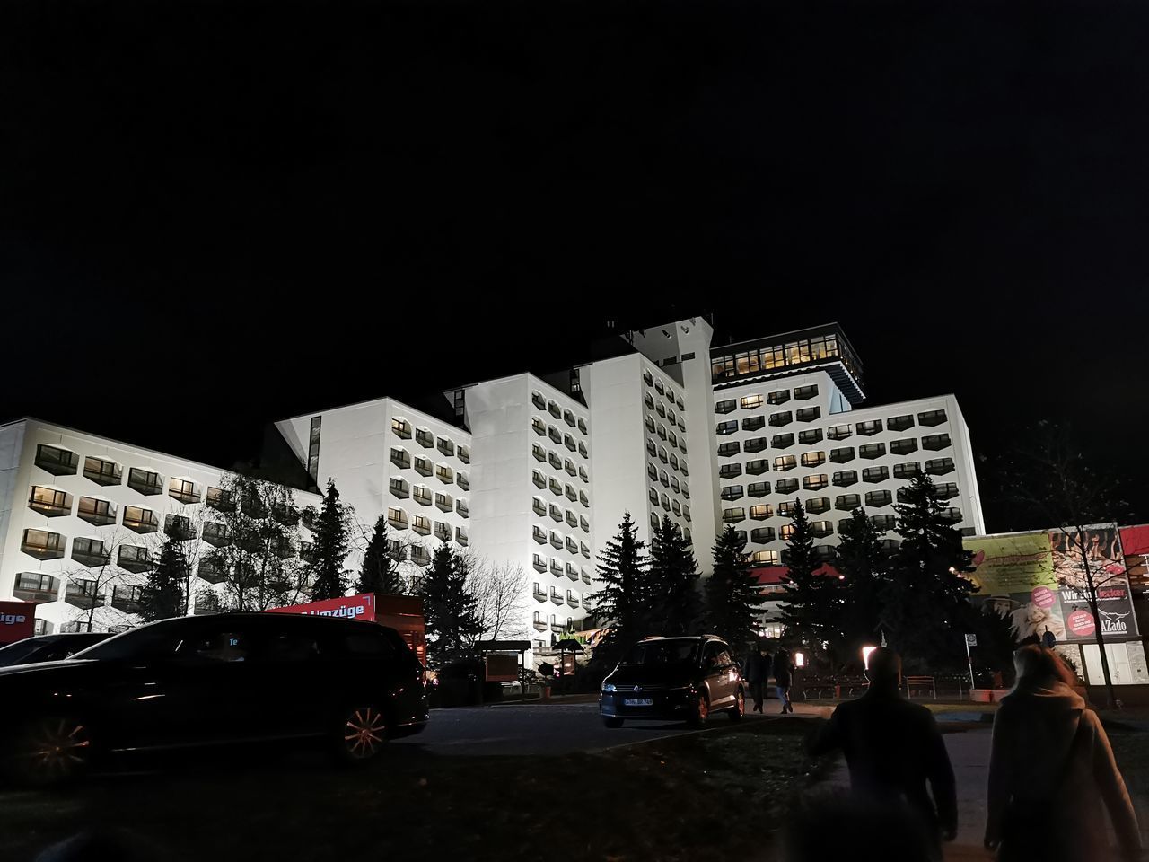 CARS ON ROAD BY BUILDINGS AGAINST SKY AT NIGHT