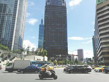 Cars on road in city against sky