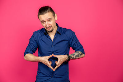 Portrait of man standing against red background