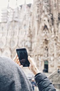 Man photographing with mobile phone in city