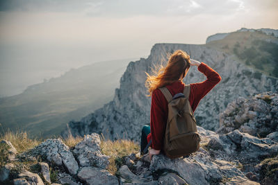 Man sitting on rock looking at mountains