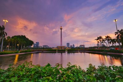 Scenic view of lake against cloudy sky during sunset