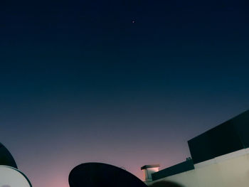 Low angle view of silhouette buildings against clear sky at night