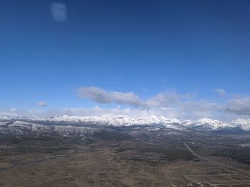 Scenic view of snowcapped mountains against blue sky