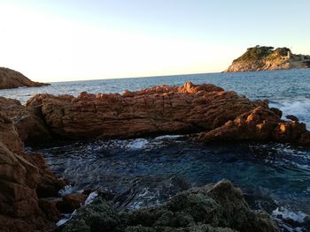 Rocks on beach against clear sky