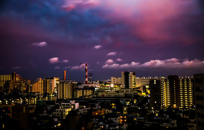 Illuminated cityscape against sky at night