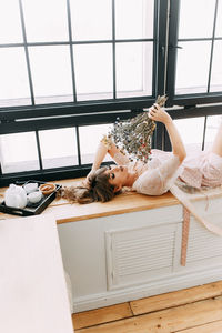 Woman lying on window