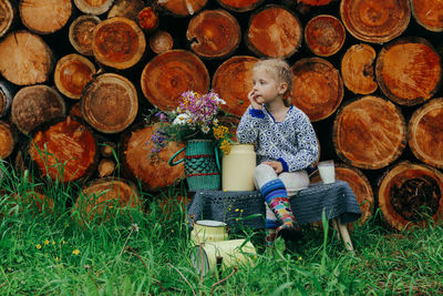 Full length of boy sitting on logs