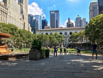 Group of people in park against buildings in city