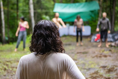 Rear view of people standing on field