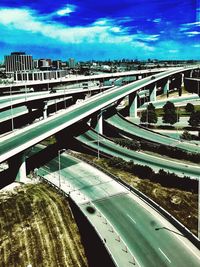 Bridge over road against blue sky in city