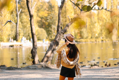 Beautiful smiling girl in casual clothes drinking coffee walking in nature in autumn outdoor