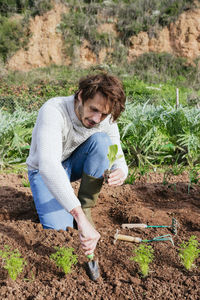 Man planting lettuce seedlings in vegetable garden