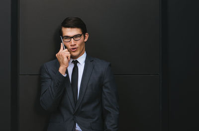 Young man wearing mask standing against wall